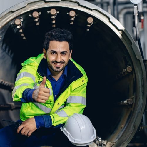 portrait engineer worker happy smiling working in factory sitting relax thumbs up